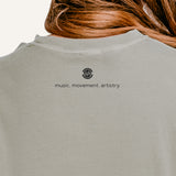 Back view of the Dance Heart Word Art long-sleeve tee showing MusicWorks’ micro-branding logo and the phrase ‘music. movement. artistry.’ printed below the neckline.